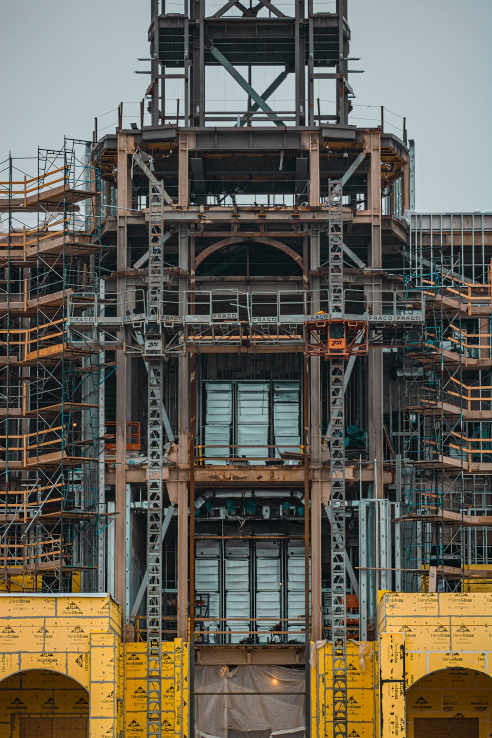Building under construction with steel framework and yellow sheathing.